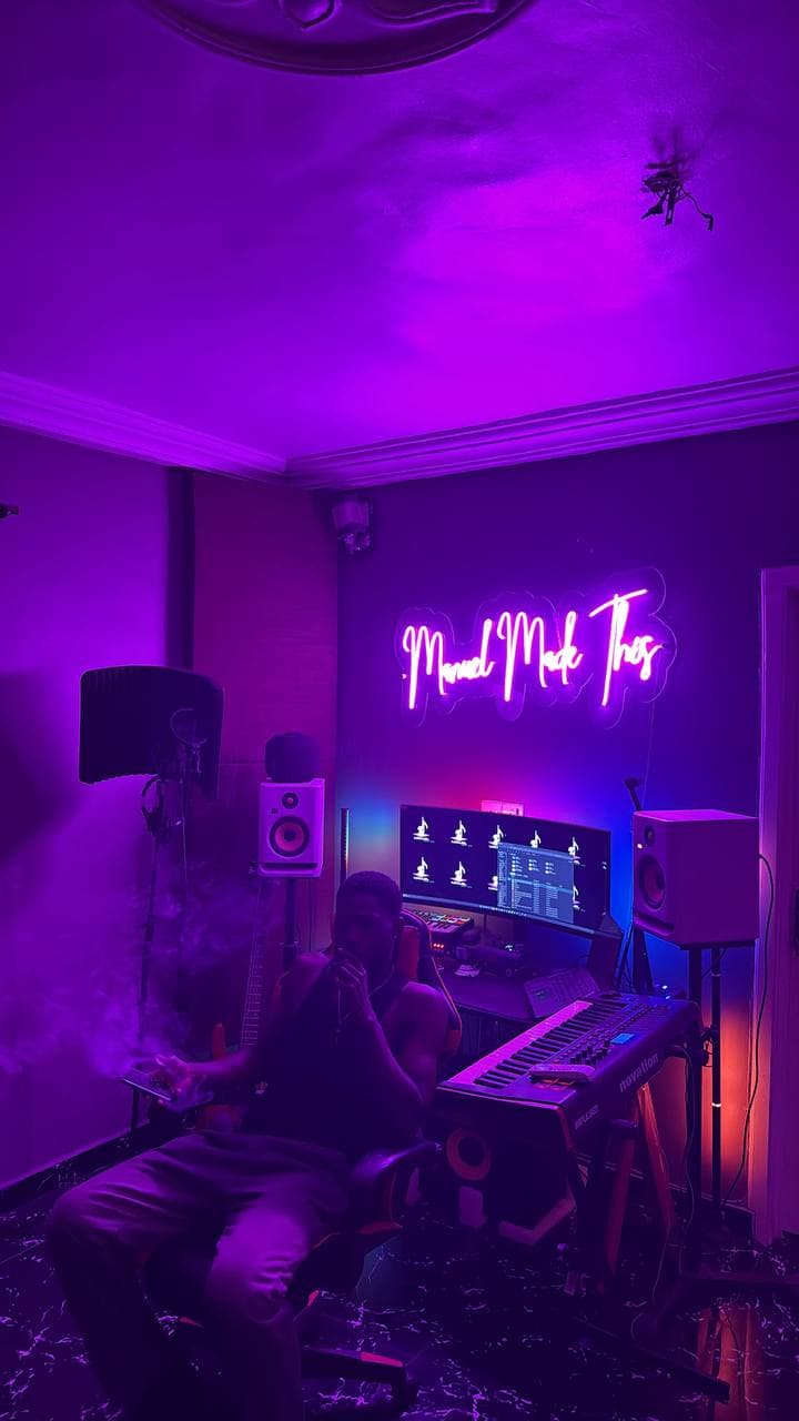 The desk under the neon sign, with someone sitting at it
