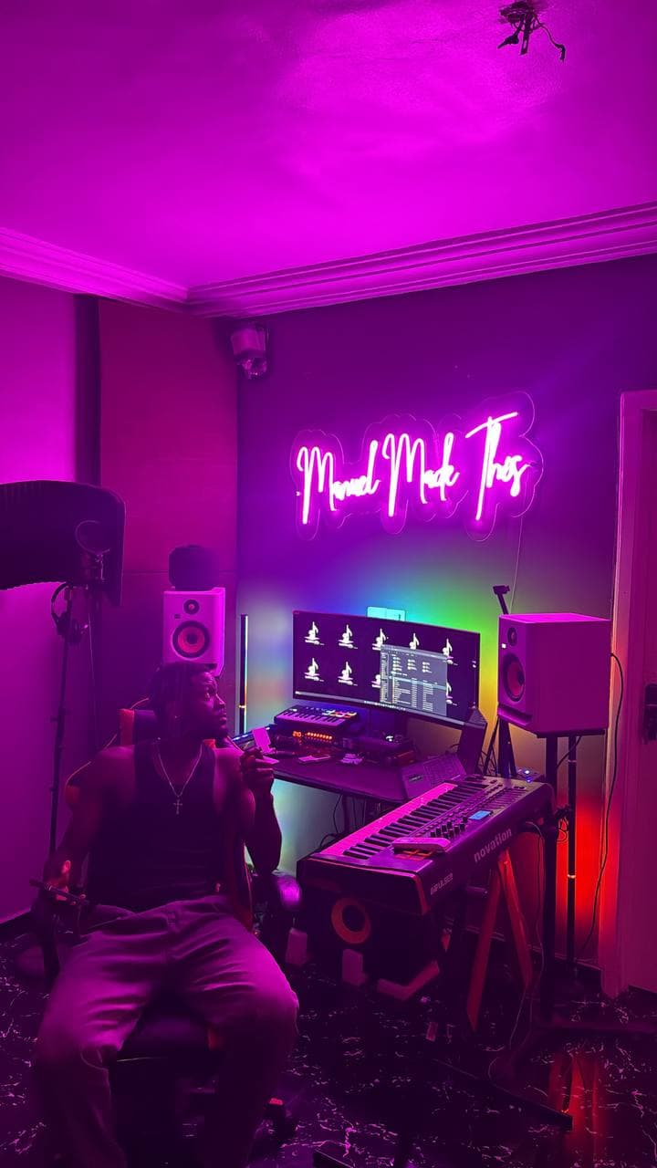 Someone sitting at the desk under the neon sign