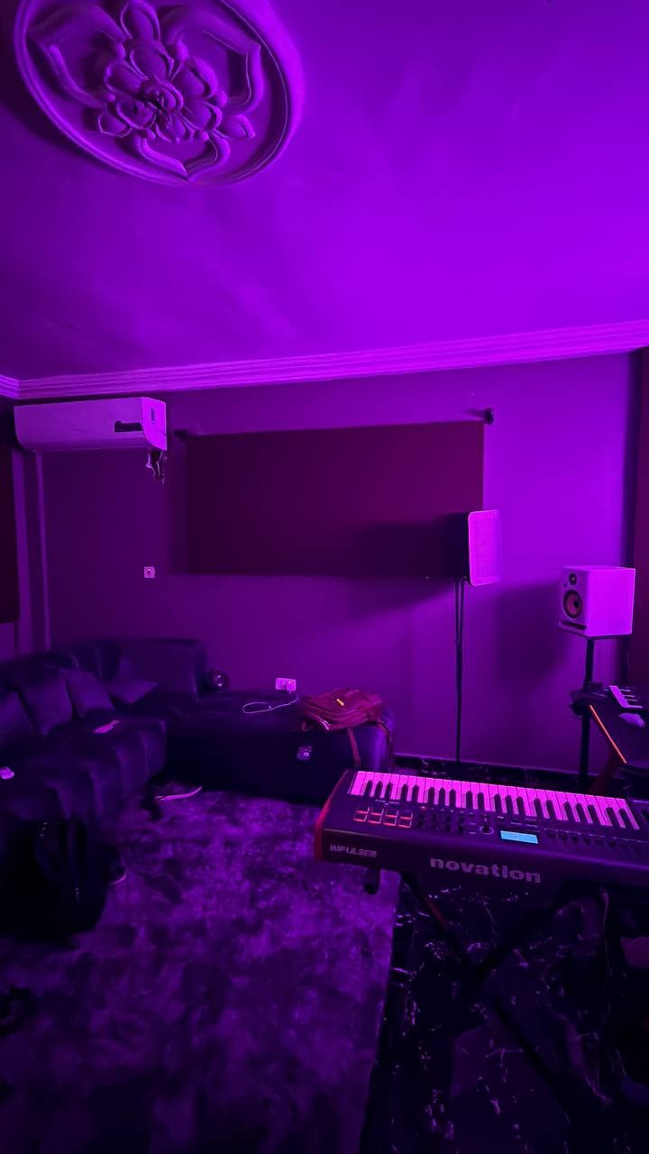 The studio's lounge corner with a sofa and rug, and a Novation keyboard in the foreground