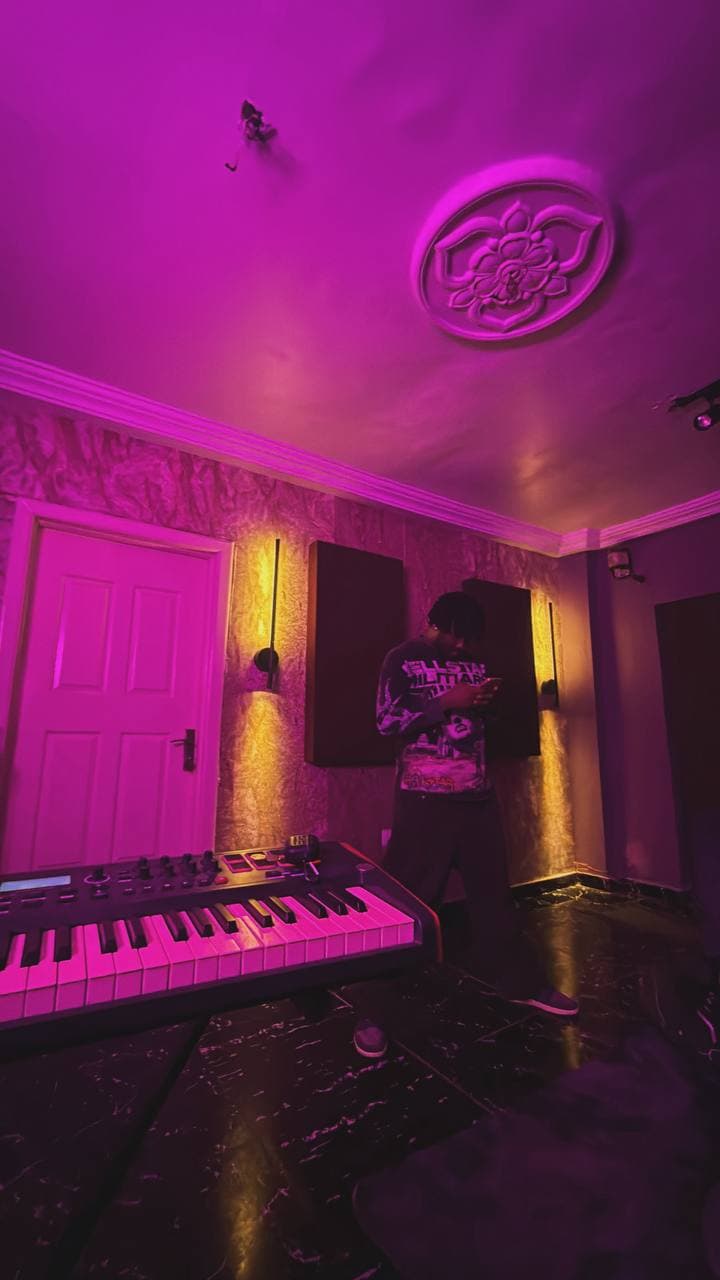 The far side of the studio lit by a warm wall lamp, with a keyboard in front